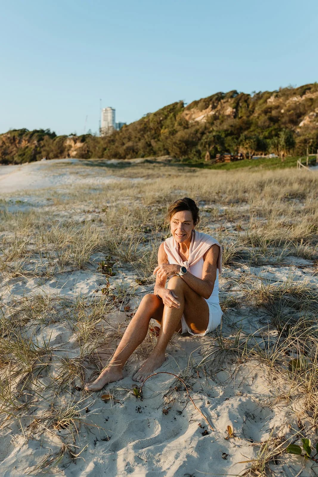Dana Eden sitting in the dunes at sunrise