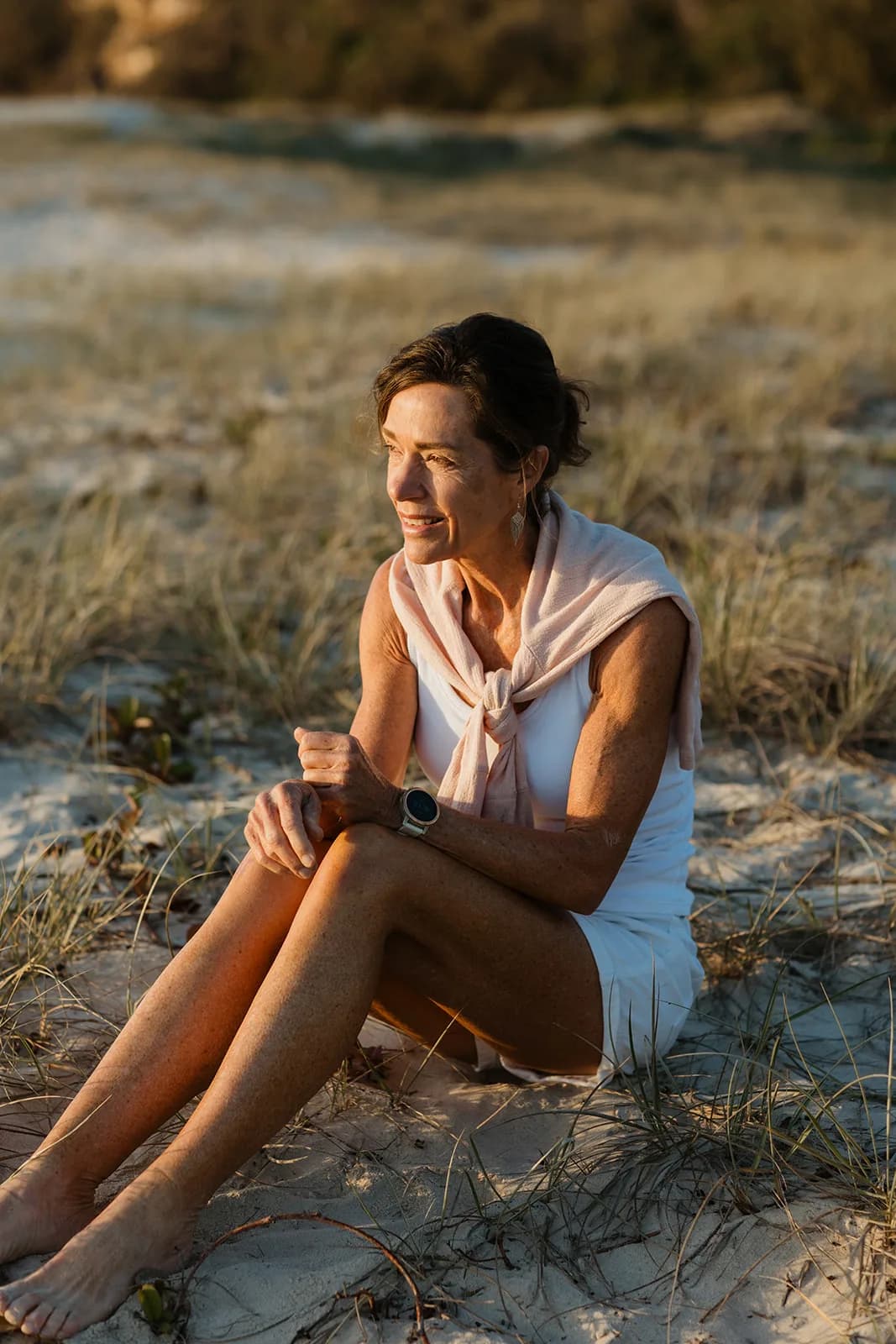Dana Eden sitting in the dunes, looking out to sea