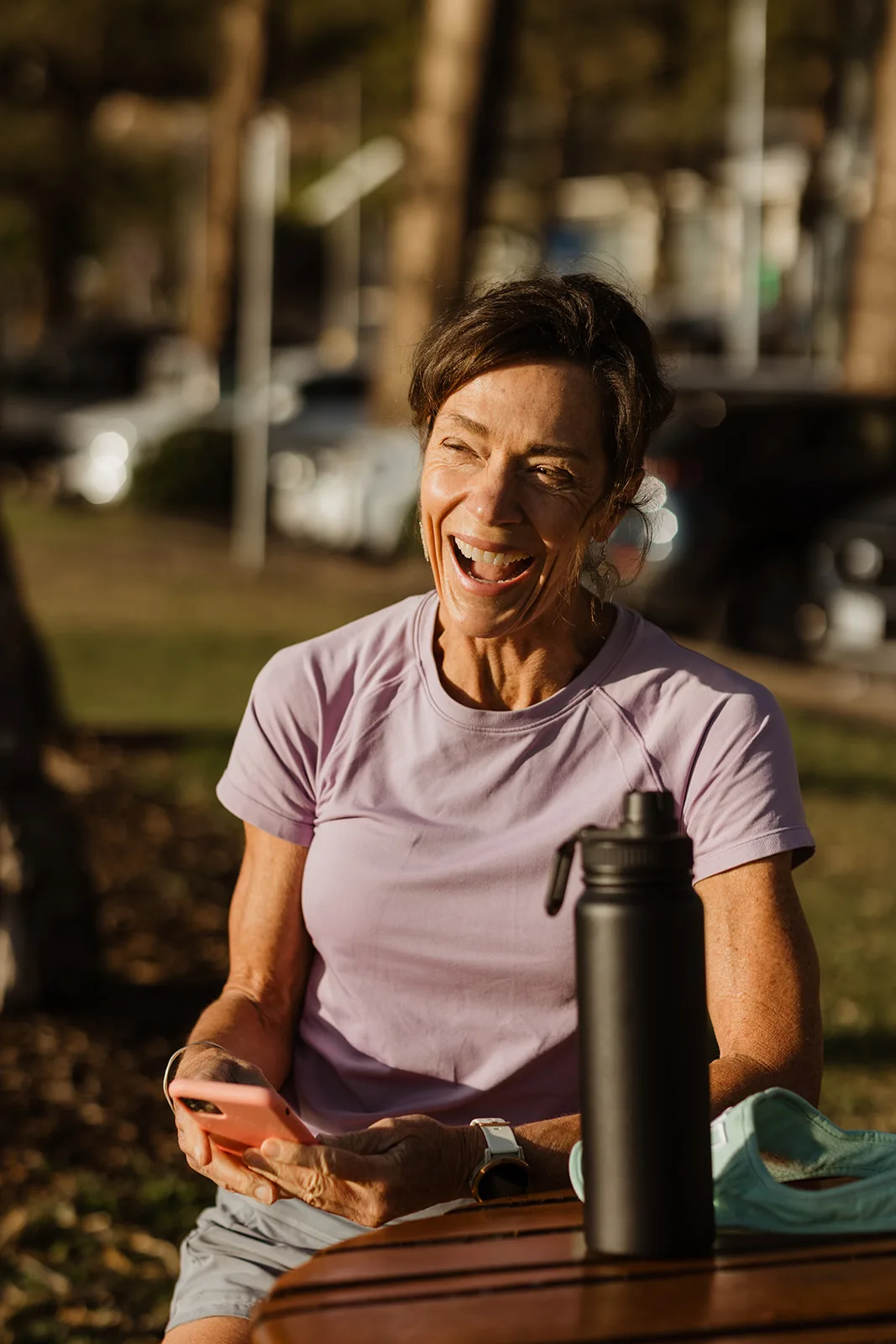 Dana Eden laughing at a cafe table by the beach