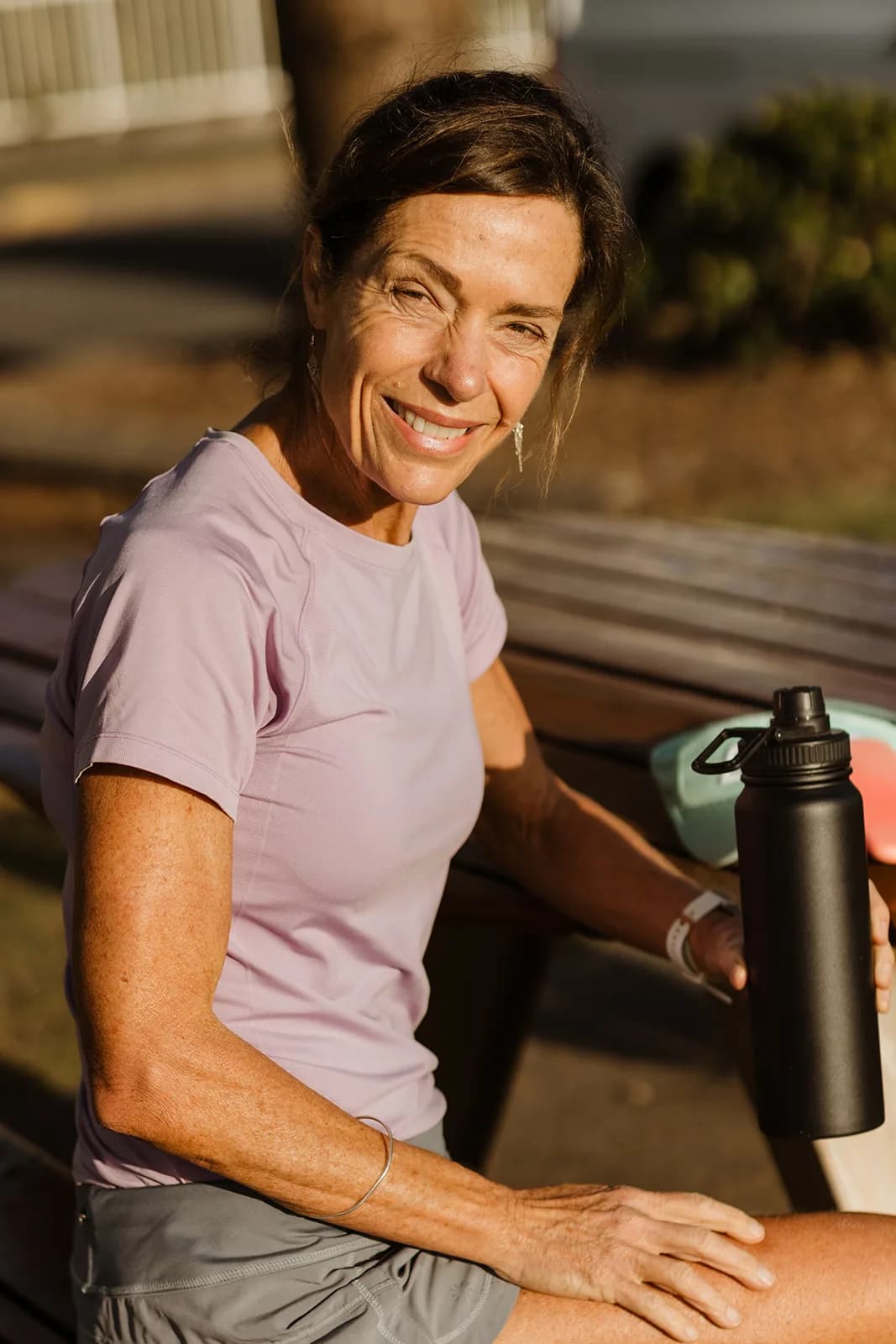 Dana Eden smiling at a cafe table by the beach