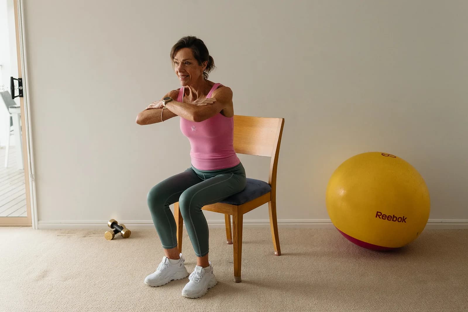 Dana Eden demonstrating a chair squat at home